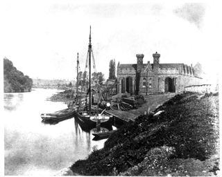 A black and white photograph or a building with crenellations and towers with sailing boats in the foreground on the riverbank.