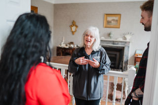 Tour Guide Talking To Guests In Front Of Fireplace At Darby Houses 04 24